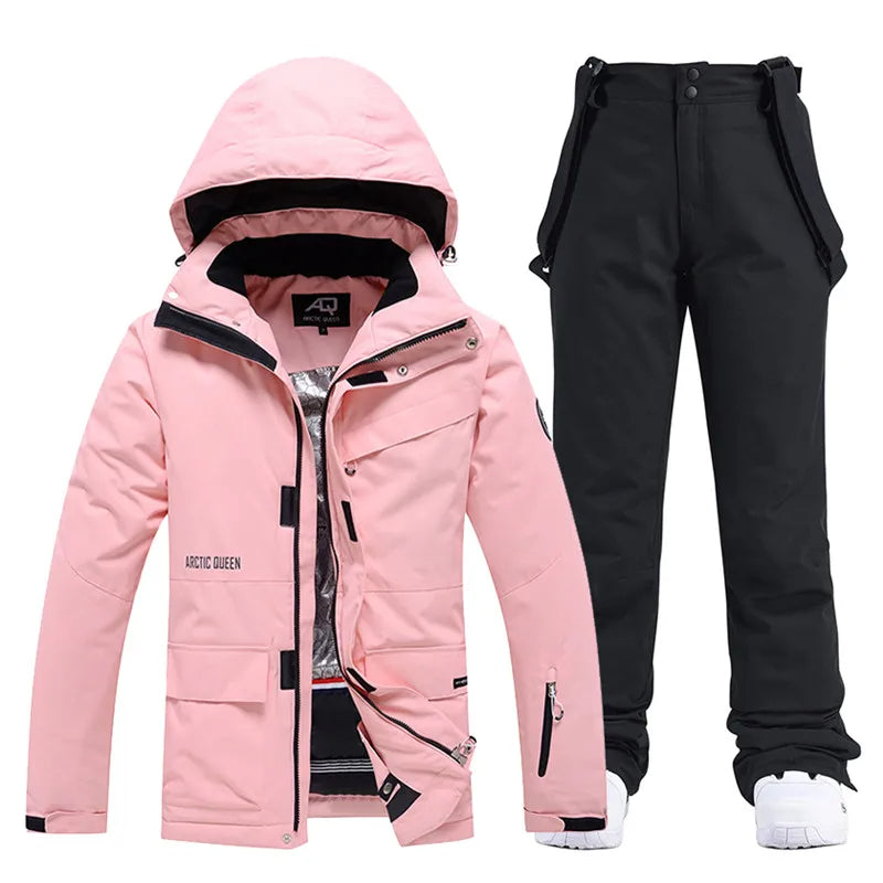 Pink women's ski jacket with hood and black ski pants set, waterproof winter sportswear.