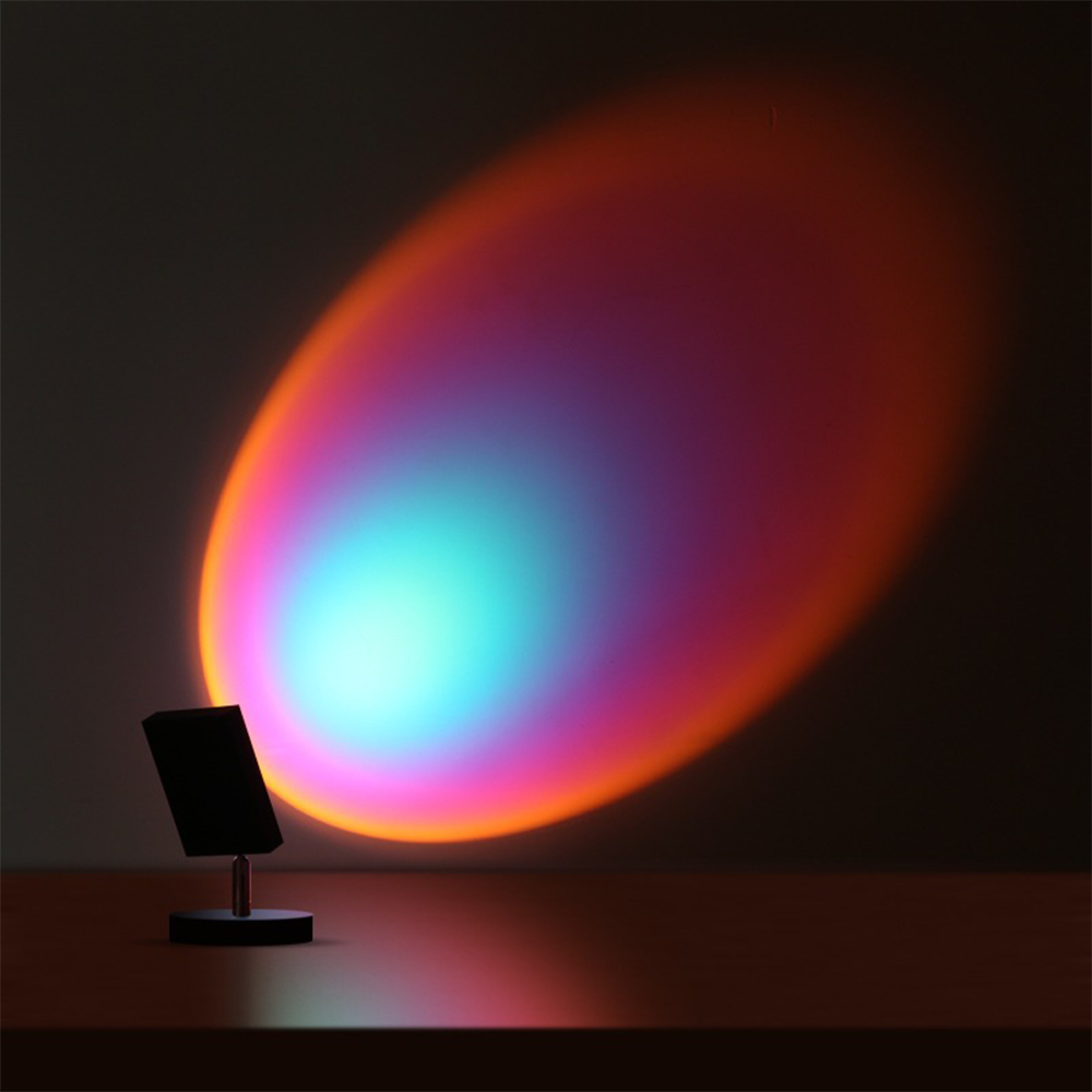 Colorful LED sunset projection lamp casting vibrant rainbow light on a wall, creating a soothing ambiance. Perfect for home decor and mood lighting.