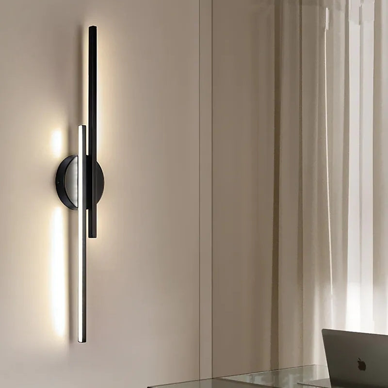 Modern wall sconce with sleek black and silver design, illuminating a minimalist room. Contemporary lighting fixture, home decor, interior design.