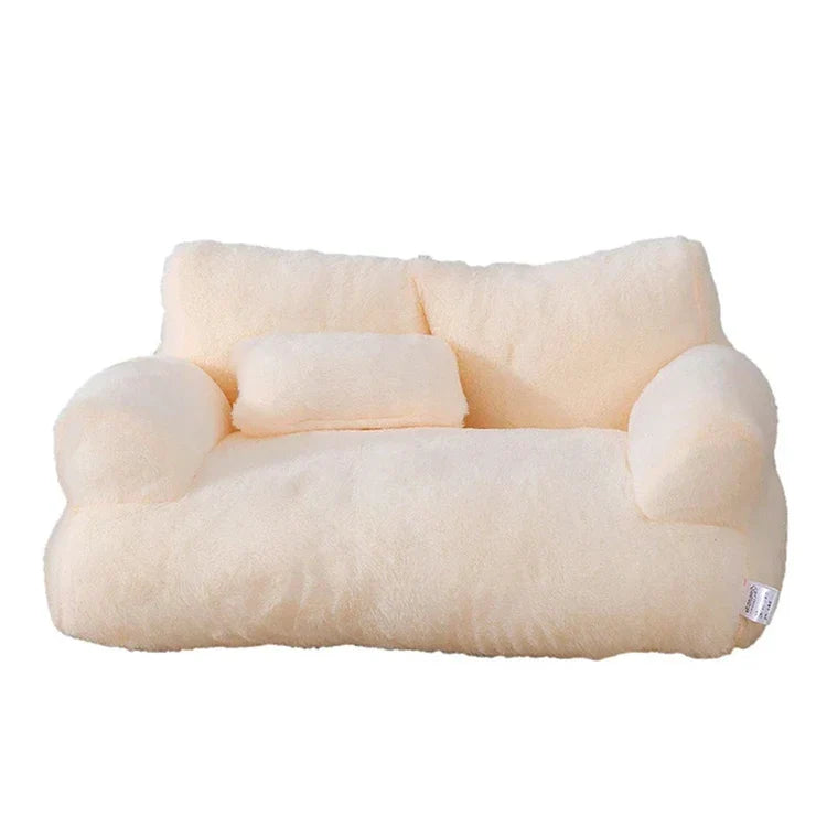 Plush cream sofa-shaped pillow with armrests and backrest, ideal for cozy home decor. Soft, fluffy texture perfect for relaxation and comfort.