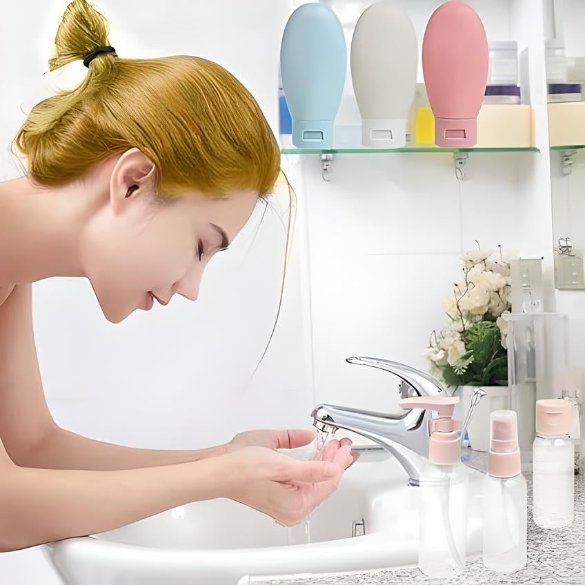 Woman washing face at bathroom sink with travel-sized toiletry bottles; modern bathroom decor, skincare routine, personal hygiene essentials.