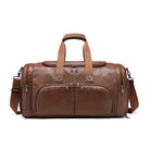 Brown leather duffel bag with dual handles, adjustable shoulder strap, and multiple zippered compartments. Stylish travel accessory for men and women.