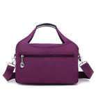 Purple women's handbag with adjustable shoulder strap, front zipper pocket, and sleek design. Perfect for travel or daily use. Fashionable and functional.