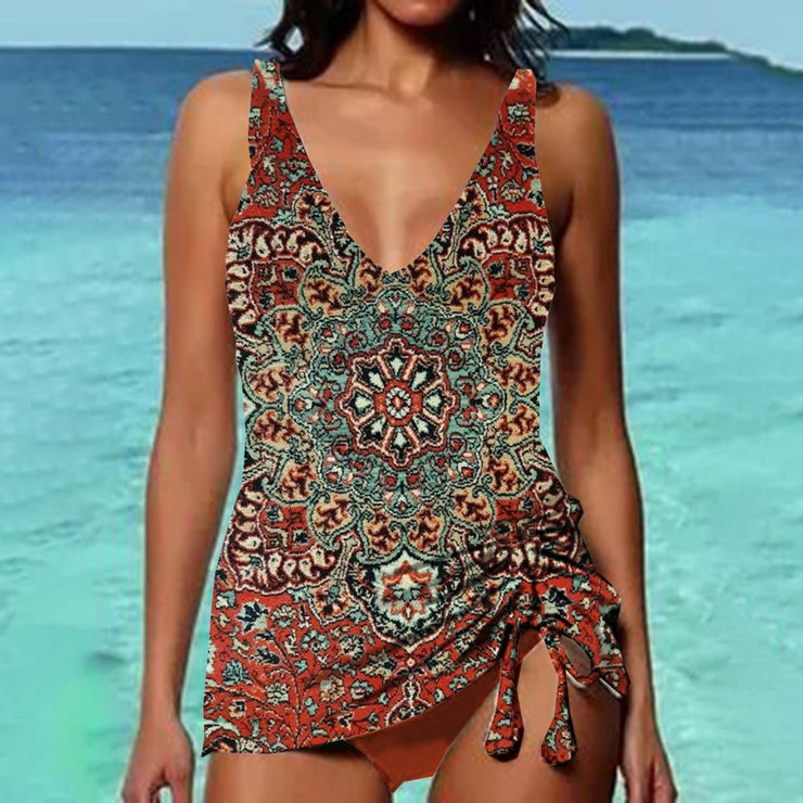 Woman wearing a bohemian paisley print swimsuit with a tie-side design, standing by the ocean. Summer beachwear, boho swimwear fashion.