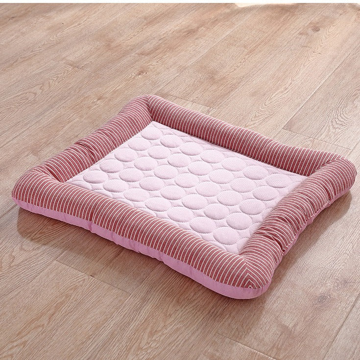 Pink striped pet bed on wooden floor, featuring a cushioned, quilted design for comfort. Ideal for small dogs or cats. Durable and stylish pet accessory.