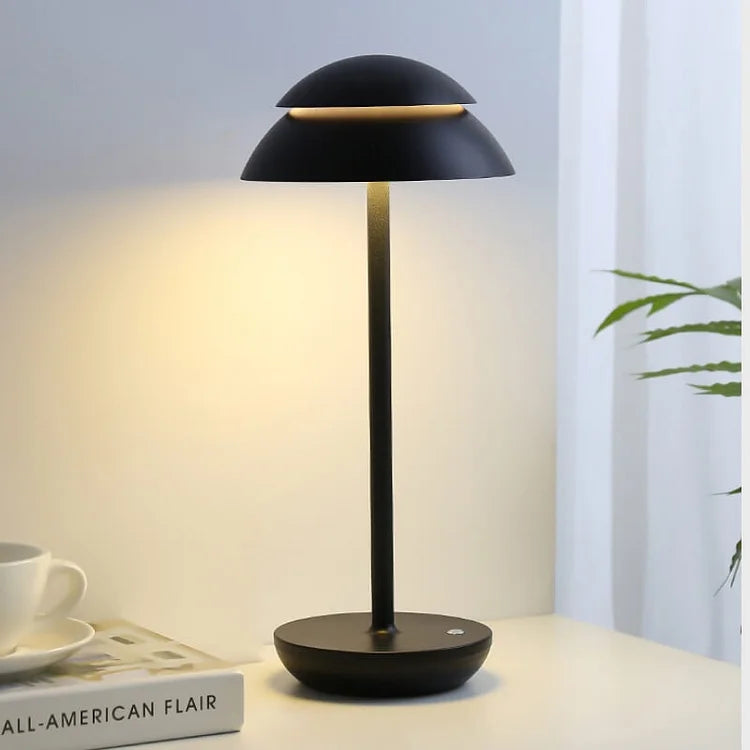 Modern black table lamp with minimalist design, featuring a dome-shaped shade, illuminating a cozy room corner. Ideal for contemporary home decor.