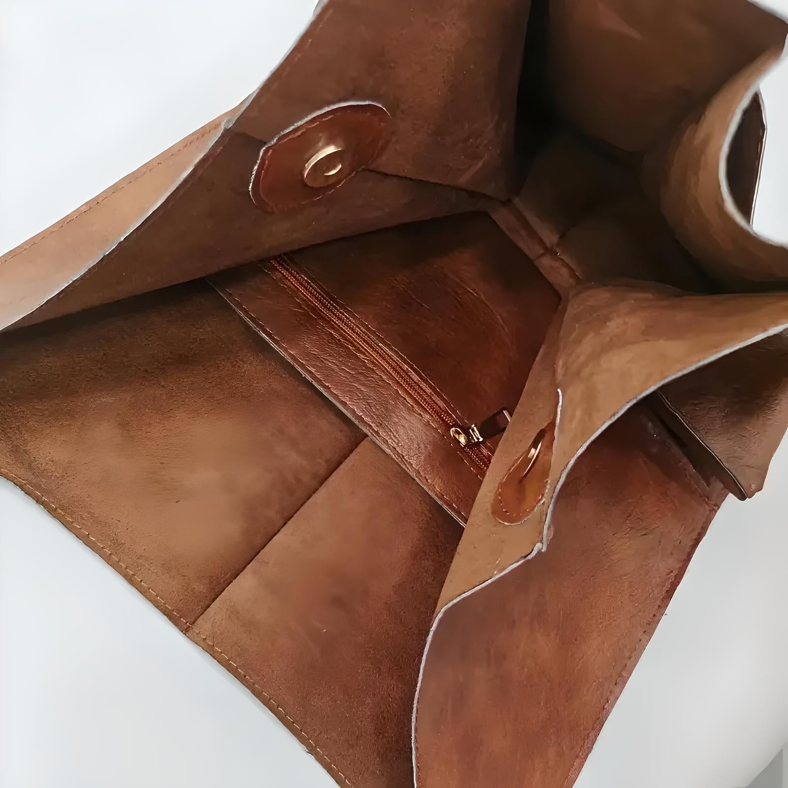 Open brown leather handbag with magnetic snap closure and interior zip pocket, showcasing craftsmanship and spacious design. Perfect for fashion enthusiasts.