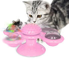 Gray tabby cat playing with a pink interactive cat toy featuring spinning balls and a textured center, ideal for pet entertainment and exercise.