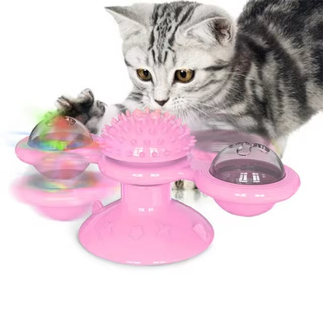 Gray tabby cat playing with a pink interactive cat toy featuring spinning balls and a textured center, ideal for pet entertainment and exercise.