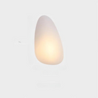 Modern minimalist wall sconce with soft ambient lighting, featuring an organic shape. Ideal for contemporary home decor and interior design lighting solutions.