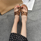 Leopard print sandals on woman's feet, gray carpet background, stylish summer footwear, casual fashion, trendy open-toe design, comfortable fit.