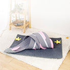 Cozy cat tunnel bed with pink and gray design on a soft rug, featuring star-shaped toys. Perfect pet accessory for playful cats and kittens.