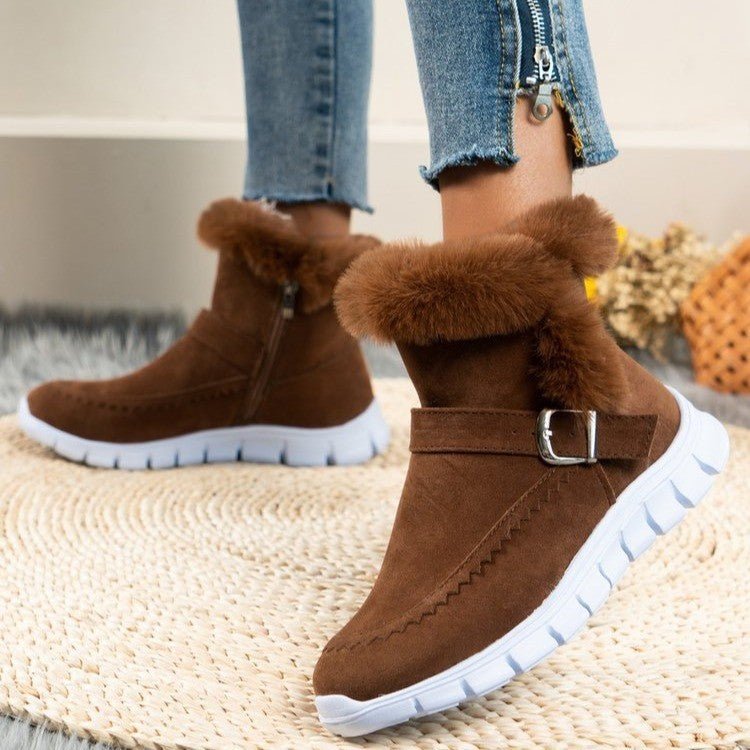 Brown suede ankle boots with faux fur lining and white rubber soles, featuring side zippers and buckle detail, perfect for winter fashion.