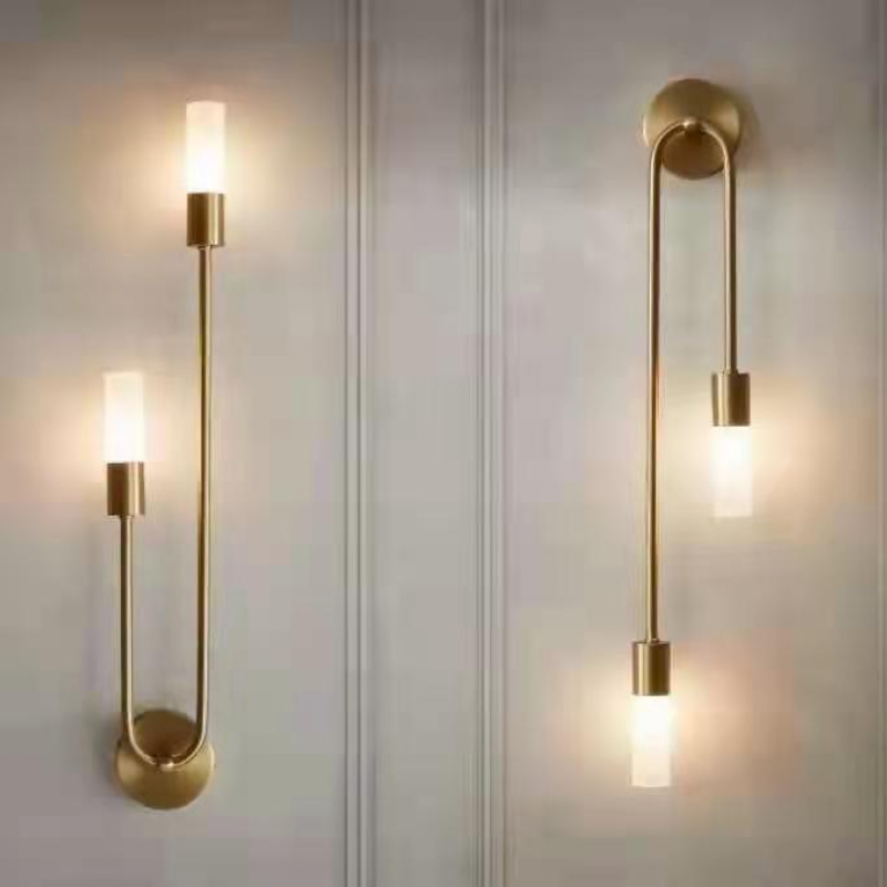 Modern gold wall sconces with cylindrical frosted glass shades, minimalist design, warm LED lighting, ideal for contemporary home decor and ambiance.