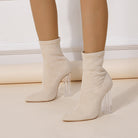 Beige sock boots with clear acrylic heels, pointed toe design, women's fashion footwear, stylish high-heeled boots, modern shoe trend.