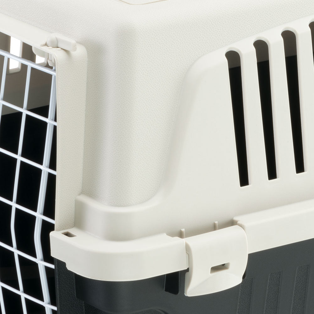 Pet carrier with secure latch and ventilation slots, featuring a durable plastic design and metal door. Ideal for safe pet transport and travel.