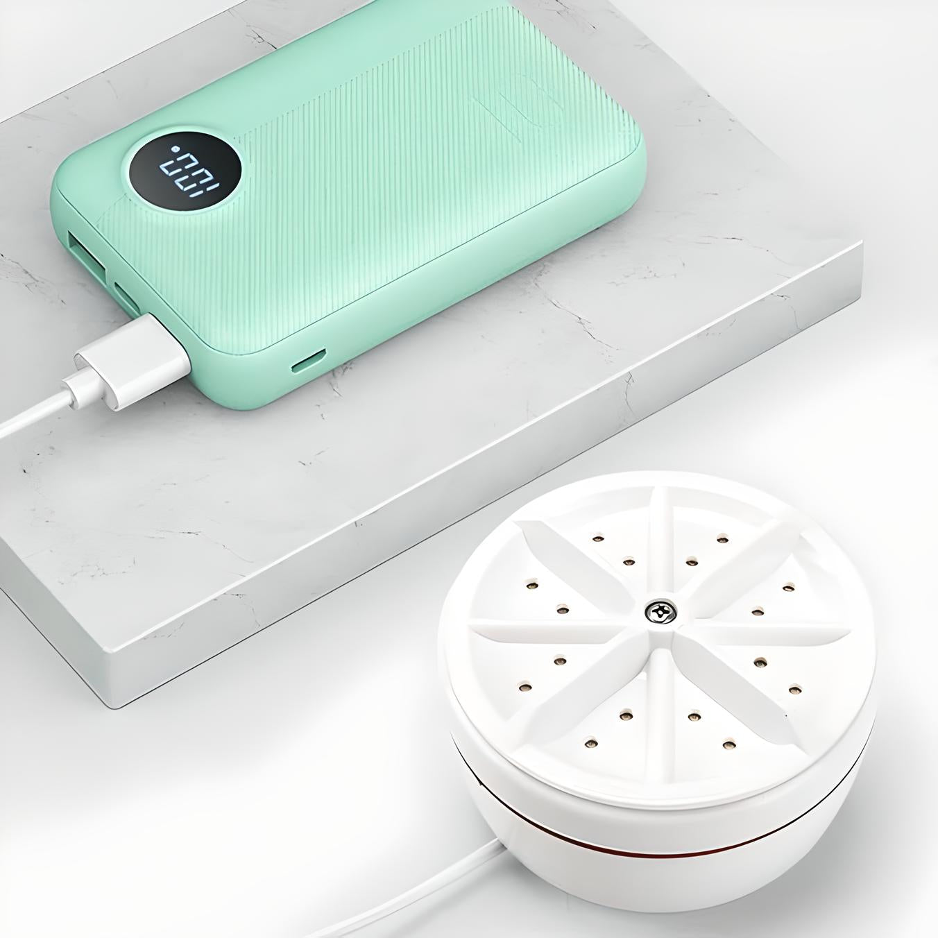 Mint green power bank with digital display charging a white portable air purifier on a marble surface. High-capacity, sleek design, USB connectivity.