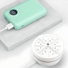 Mint green power bank with digital display charging a white portable air purifier on a marble surface. High-capacity, sleek design, USB connectivity.