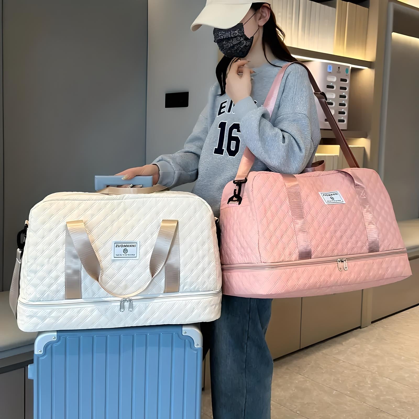 Woman in casual attire holding a pink quilted travel duffel bag, standing next to a cream quilted carry-on suitcase. Travel fashion accessories.