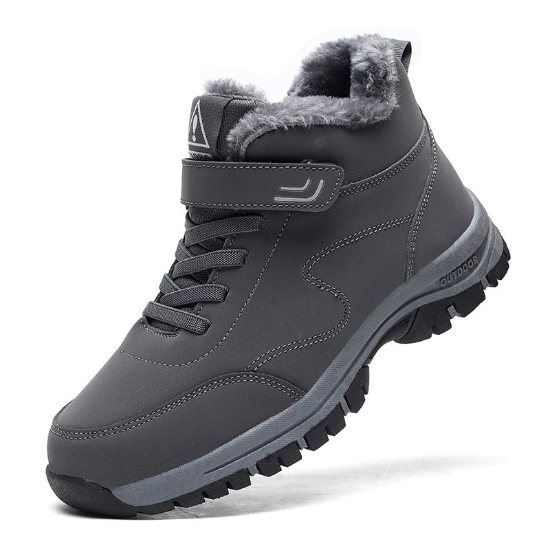 Dark gray winter boot with plush lining, durable sole, and lace-up design for men and women. Ideal for outdoor activities. Stylish and warm footwear.