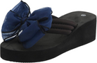 Women's black platform sandal with a large blue bow, featuring a thick sole and cushioned straps. Stylish summer footwear, trendy wedge design.