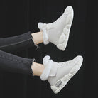 White high-top sneakers with fur lining, chunky sole, and zipper detail, perfect for winter fashion. Stylish women's footwear, casual streetwear.