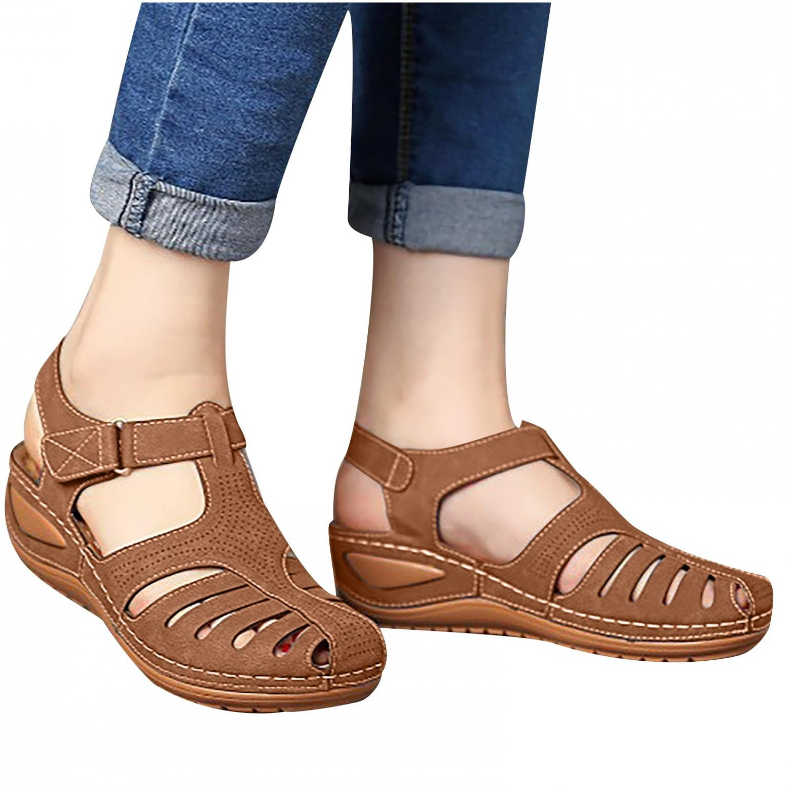 Brown orthopedic sandals with adjustable straps, worn with rolled-up jeans. Comfortable, supportive footwear for women. Ideal for casual outings.