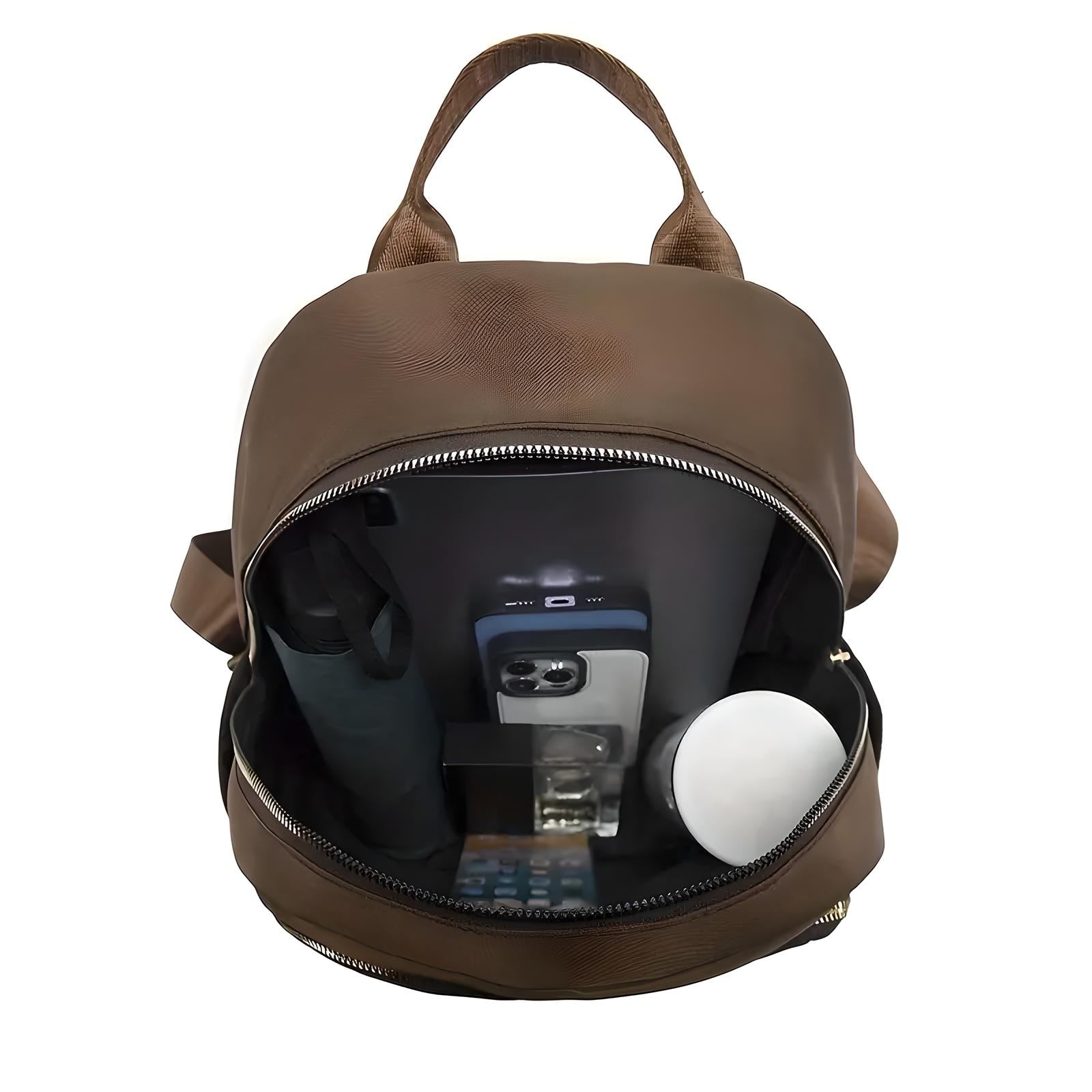 Open brown leather backpack with visible contents including a water bottle, smartphone, notebook, and calculator. Ideal for travel or school use.