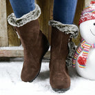 Brown faux fur-lined winter boots on snow, paired with blue jeans. Cozy, stylish footwear ideal for cold weather. Perfect for winter fashion.