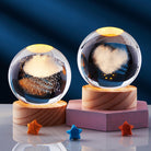 Glass storm cloud weather predictor with heart and cloud designs on wooden bases, ambient lighting. Unique home decor, weather forecasting gift.