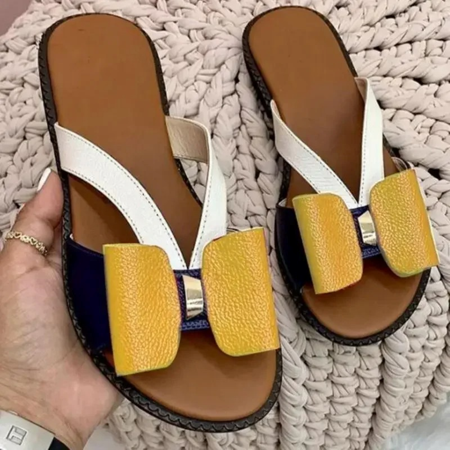 Women's stylish sandals with yellow bow accents, white straps, and brown soles. Perfect for summer fashion and casual wear. Comfortable and trendy footwear.