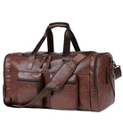 Brown leather duffel bag with multiple pockets, adjustable shoulder strap, and sturdy handles. Ideal for travel, gym, or weekend trips.