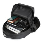 Open black backpack with laptop, notebooks, headphones, and gadgets. Ideal for tech-savvy travelers and students. Durable, spacious, and organized.