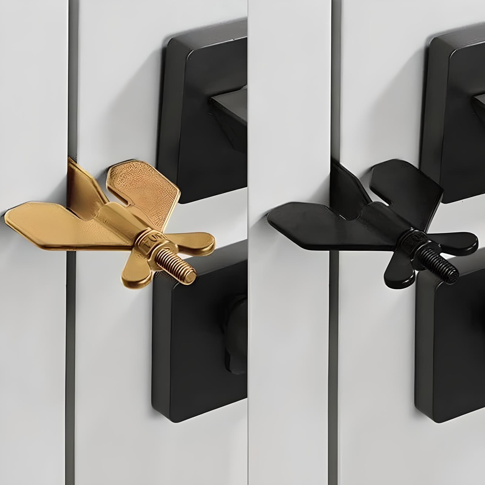 Gold and black butterfly-shaped cabinet knobs on white doors, modern home decor hardware, stylish interior design accessories, unique drawer pulls.