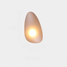 Modern minimalist wall sconce with soft ambient lighting, featuring an organic shape and warm glow. Ideal for contemporary home decor and lighting design.