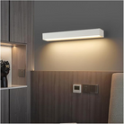 Modern LED wall sconce in a minimalist bedroom setting, featuring sleek design, warm ambient lighting, and energy-efficient technology.