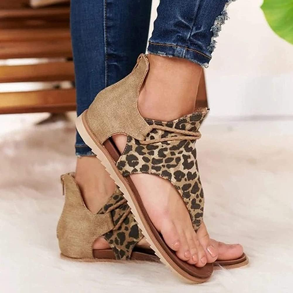 Leopard print open-toe sandals with ankle strap, worn with ripped jeans on a white fur rug. Fashionable women's summer footwear.