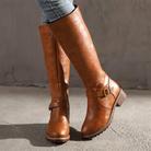 Women's brown leather knee-high boots with buckle detail, low block heel, and side zipper. Stylish fall footwear for casual and formal outfits.