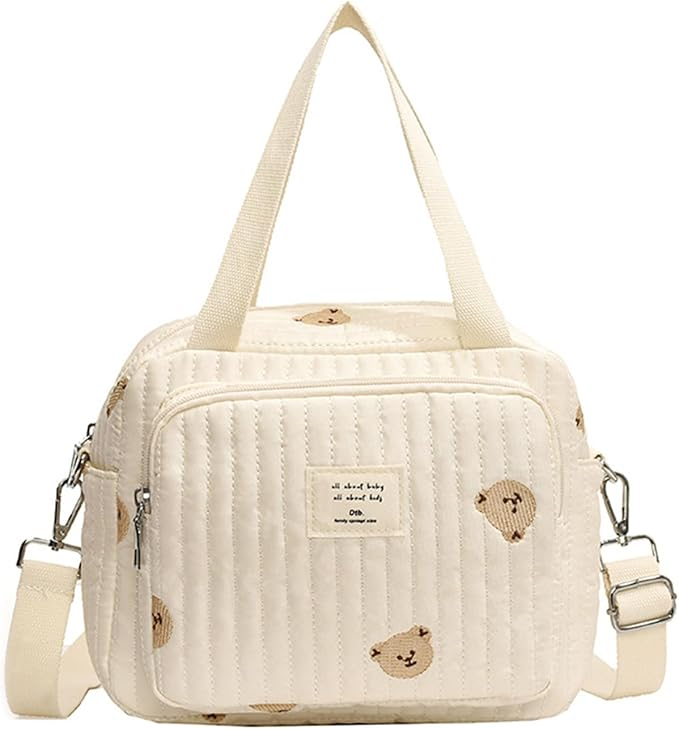 Quilted beige diaper bag with cute bear print, adjustable shoulder strap, and front pocket. Ideal for baby essentials. Stylish and functional.