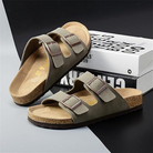 Olive green double-strap sandals with cork footbed on a black and white background, ideal for casual wear. Comfortable, stylish footwear.