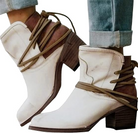 White leather ankle boots with brown wraparound laces, block heels, and distressed finish, paired with rolled-up jeans. Fashionable women's footwear.