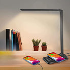 Sleek LED desk lamp with wireless charging pad, USB port, and adjustable arm on wooden desk; ideal for modern home office lighting solutions.