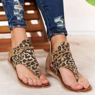 Leopard print women's sandals with open toe design, paired with ripped jeans. Stylish summer footwear, casual fashion, trendy animal print shoes.