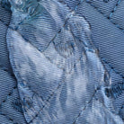 Close-up of textured blue fabric with intricate stitching and glossy overlay, showcasing detailed craftsmanship and unique textile design.