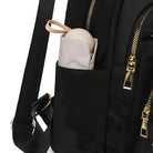 Black backpack with gold zippers, featuring a side pocket holding a beige umbrella. Stylish travel accessory, perfect for daily use and organization.