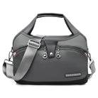 Stylish gray fashion handbag with adjustable shoulder strap, multiple zippered compartments, and sleek design. Perfect for travel or daily use.