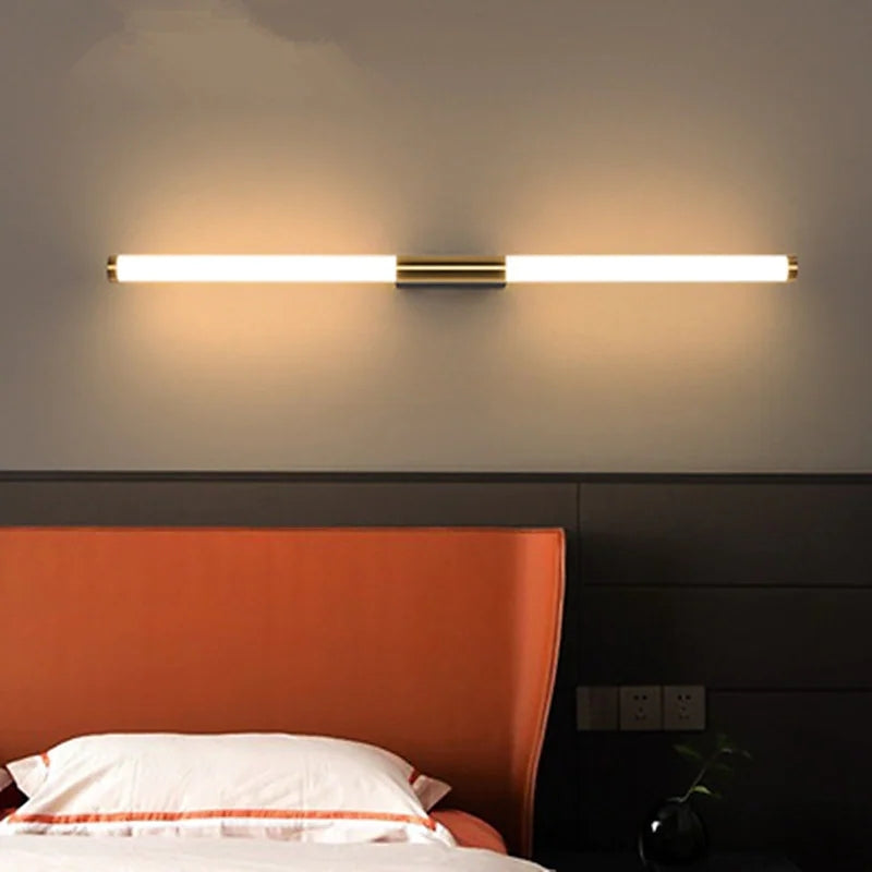 Modern LED wall light fixture above orange headboard in bedroom; sleek, minimalist design; energy-efficient lighting; home decor.