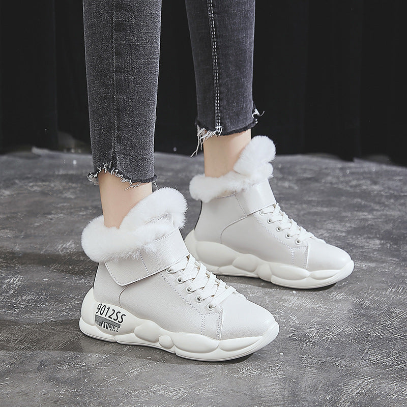 White fur-lined high-top sneakers with chunky soles, worn with frayed hem jeans. Stylish winter footwear, perfect for casual fashion and comfort.