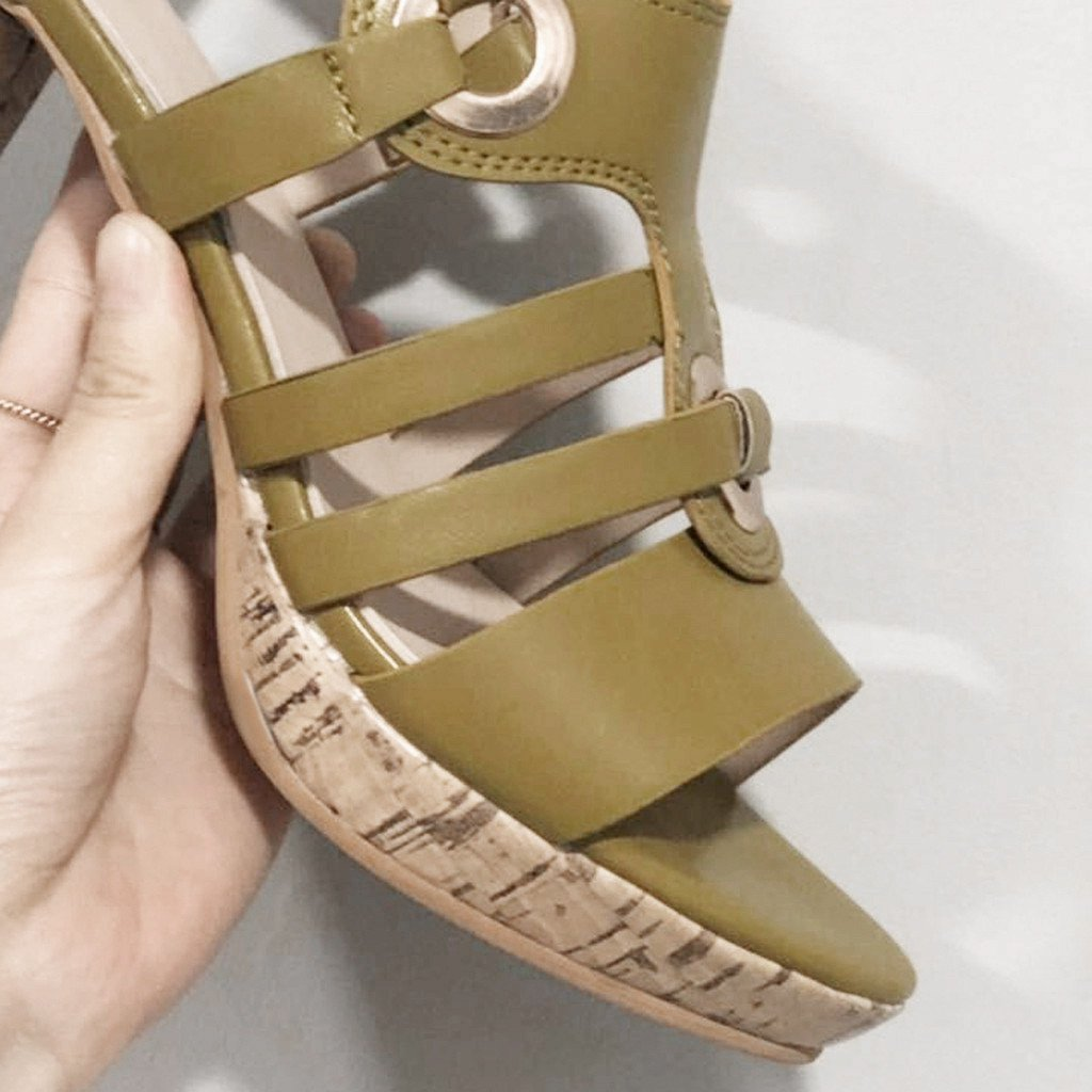 Olive green wedge sandal with cork sole, featuring strappy design and gold buckle detail. Perfect for summer fashion and casual wear.