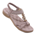 Women's beige sandal with rhinestone embellishments, cushioned sole, and elastic ankle strap. Stylish summer footwear, perfect for casual wear.